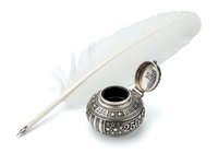 White feather quill pen with ornate silver inkwell featuring decorative metalwork and open lid, isolated on white background for design, clipart, and vintage writing projects.