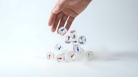 Hand placing white dice with colorful arrows pointing in different directions, symbolizing decision making, choice, strategy and business direction concepts.