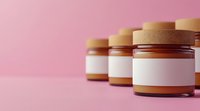 Glass jars with blank white labels lined up on pink background, mockup for cosmetics, food products or natural skincare packaging design presentation.