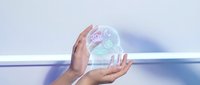 Hands holding futuristic holographic interface with glowing data visualization and digital elements for technology and innovation concepts.