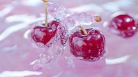 Fresh red cherries splashing in pink liquid with water droplets and bubbles creating dynamic movement for food photography.