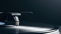 Professional turntable with tonearm and vinyl record in dramatic lighting setup for music production and DJ equipment photography.