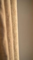 Natural beige linen fabric texture with soft folds and weave detail for home decor and textile design projects.