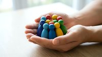 Hands holding colorful wooden figures representing diversity, unity, teamwork, and community support for business, nonprofit, and social cause campaigns.