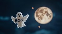 Playful ghost decoration with boo text floating against full moon night sky background, spooky halloween atmosphere with glowing celestial elements and dark clouds.