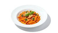 Penne pasta with tomato sauce, garnished with fresh basil and grated cheese, served on a white plate for restaurant menus and food blogs.