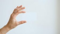 Caucasian male hand gesturing holding or measuring invisible object against white background for business, presentation, or product display concepts.