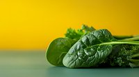 Fresh green spinach leaves bunch on yellow background for healthy cooking and nutrition concepts.