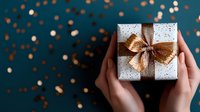 Hands holding elegant gift box with copper bow on dark background with festive bokeh lights and glitter. Perfect for holiday and celebration designs.