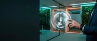 Businessman in dark suit touching glowing digital lightbulb hologram on transparent screen in modern office with green plants, representing innovation, technology, and creative business solutions.