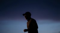 Male runner in silhouette jogging outdoors at dusk against twilight sky, athletic training and fitness concept for sports and wellness campaigns.