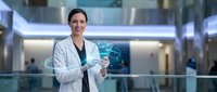 Professional female doctor in white coat using holographic brain interface technology in modern medical facility for healthcare innovation and diagnosis.