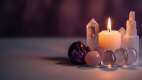 Spiritual healing crystals with burning candle creating peaceful meditation atmosphere for wellness and mindfulness practices.