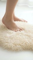 Bare feet stepping on soft fluffy cream carpet in cozy home interior for comfort and relaxation wellness spa treatment concept.