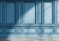 Classic blue wall paneling with decorative molding and wainscoting creates elegant interior backdrop, illuminated by soft natural light on gray floor.