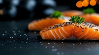 Fresh raw salmon fillet slices garnished with black sesame seeds and parsley on dark background with selective focus and bokeh lights.