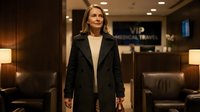 Professional businesswoman in elegant black coat standing confidently in upscale corporate lobby with modern lighting and luxury furnishings.