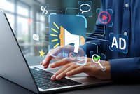 Digital marketing concept with businessman hands typing on laptop and floating megaphone icon surrounded by advertising symbols and communication elements.