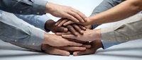 Diverse business team hands stacked together showing unity, teamwork and collaboration in corporate environment for success and partnership goals.