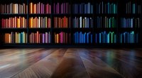 Colorful books arranged on dark wooden shelves creating rainbow spectrum effect, illuminated against black background with reflective hardwood flooring.