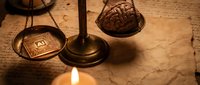 Ancient bronze scales of justice with brain and microchip on wooden surface by candlelight representing technology versus human intelligence balance.