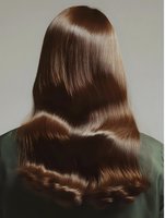 Long glossy brown hair shown from behind on woman wearing green top, demonstrating healthy, smooth, straight hairstyle with natural wave at ends.