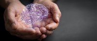 Hands gently holding glowing purple brain hologram representing mental health, neuroscience, psychology, artificial intelligence and cognitive wellness concepts.