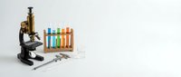 Laboratory equipment with microscope and colorful test tubes for scientific research and educational experiments on white background.