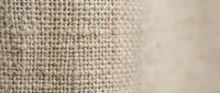 Natural burlap fabric texture with woven fibers in beige and brown tones, close-up macro photography showing detailed textile pattern for rustic design projects.