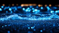 Mesmerizing blue water splash with glowing bokeh lights creating magical atmosphere against dark background, macro photography of liquid motion.