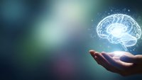 Human hand holding glowing digital brain hologram with neural network connections on blurred gradient background for artificial intelligence concepts.