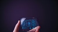 Hands holding futuristic holographic device with digital interface and glowing blue technology icons, representing innovation, connectivity, and advanced digital solutions.