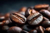 Macro shot of roasted coffee beans with two prominent beans in focus showing detailed texture against dark background.