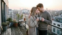 Couple embracing on urban rooftop terrace at sunset, enjoying intimate moment with cityscape view. Romantic scene for lifestyle, relationships, and dating content.