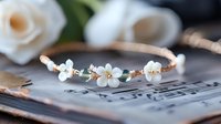 Elegant rose gold floral headband with white pearl flowers resting on vintage sheet music, perfect for bridal accessories and wedding photography.