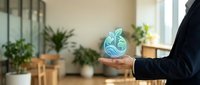 Businessperson in dark suit holding glowing brain icon representing artificial intelligence, innovation and digital technology in modern office environment with plants.