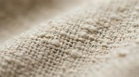 Natural burlap fabric texture with woven fibers in beige and brown tones for rustic design projects and organic material backgrounds.