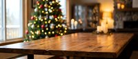Wooden table surface with blurred Christmas tree and cozy home interior background for holiday product display and seasonal marketing campaigns.