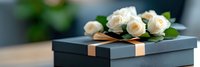 Elegant black gift box with gold ribbon and white roses on wooden surface for special occasions and luxury gifting concepts.