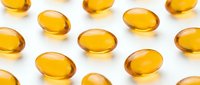 Golden amber gel capsules arranged on white background, representing vitamins, supplements, omega-3 oils, or pharmaceutical products for health and wellness.