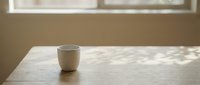 Minimalist ceramic mug on marble table with natural sunlight casting shadows, suitable for lifestyle, home decor, and beverage product marketing.