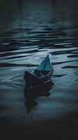 Paper boat floating on dark moody water surface with ripples and reflections, illuminated by mysterious blue light, creating atmospheric scene.