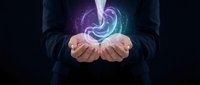 Businessman holding glowing purple energy spiral in cupped hands against dark background for technology and innovation concepts.
