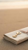 Golden key resting on open notebook pages against neutral beige sand background, symbolizing unlocking knowledge, secrets, solutions, and success for educational and business concepts.