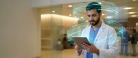 Male doctor using digital tablet with holographic interface technology in modern hospital corridor for medical innovation and healthcare advancement.