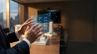 Businessman in dark suit interacting with holographic digital display showing data visualization and network connections in modern office with city skyline view.