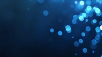 Glowing blue bokeh lights scattered on dark background create magical atmosphere, soft focus circular light spots for festive designs and overlays.