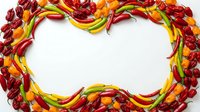 Hot chili peppers in red, yellow and green arranged in a frame border with white copy space, suitable for food packaging, recipe blogs and culinary designs.