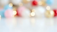 Soft blurred bokeh lights background with warm golden and colorful circles creating dreamy atmosphere for holiday celebrations and festive designs.