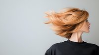 Young woman with flying peach blonde hair wearing black sweater against light background, profile view capturing dynamic hair movement in modern minimalist style.